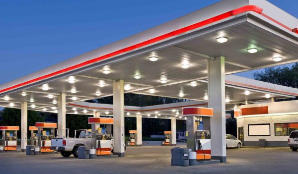 Horizontal shot of a retail gasoline station and convenience store at dusk.