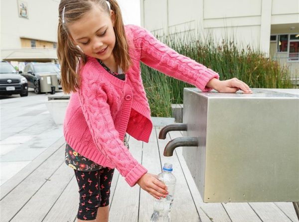 little girl refilling water bottle