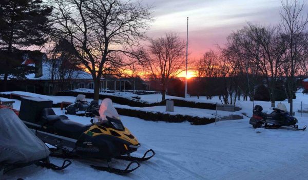 Looking out at the sunset past a few snowmobiles at Mackinac Island.