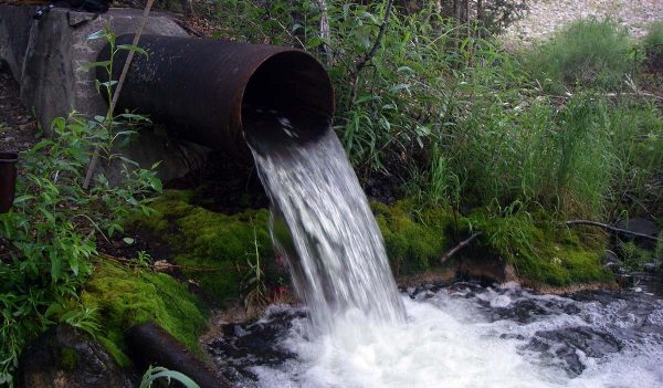 Water pouring from a pipe into a stream