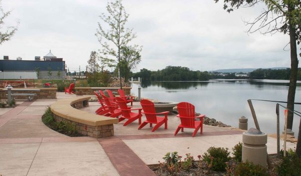 Red patio chairs sitting along the waterfront on Wisconsin River shoreline in Wausau, Wisconsin