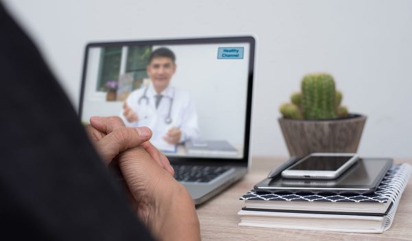 Patient listening to friendly doctor via laptop computer at home or office, telemedicine, e health. People watching doctor on health channel internet live broadcast, medical online concept