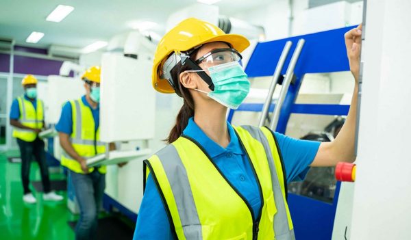 Technician or worker or engineer woman with hygienic mask stand with confident action in workplace during concern about covid 2019 pandemic in people affect industrial business.