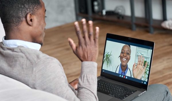 Male african patient on conference video call with female online doctor.