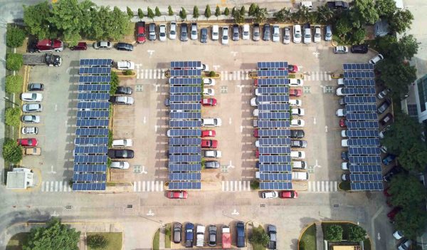 Parking lot with solar panels for charging cars above top view