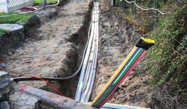 Construction site for installing fiber optic cables under the ground beside a street to bring fast internet to all residents, selected focus, narrow depth of field
