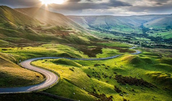 Sunset at Mam Tor, Peak District National Park, with a view along the winding road down to Hope Valey, in Derbyshire, England.