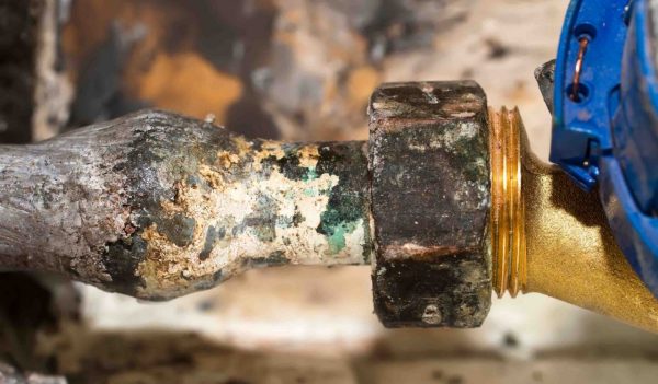 Close-up of a corroded lead pipe.