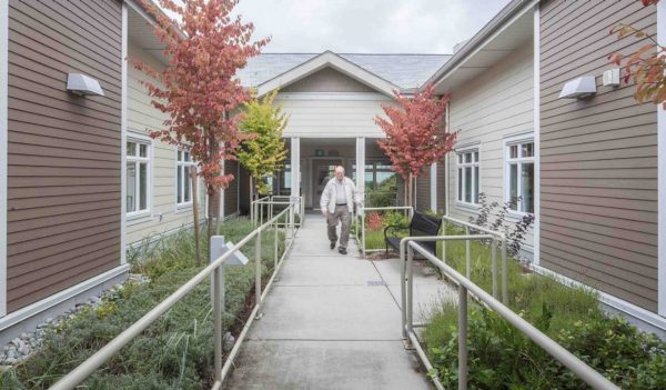 Senior citizen walking outside of a care home.