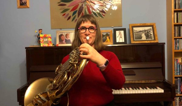 Jo Wittington on a horn instrument with a piano in the background.