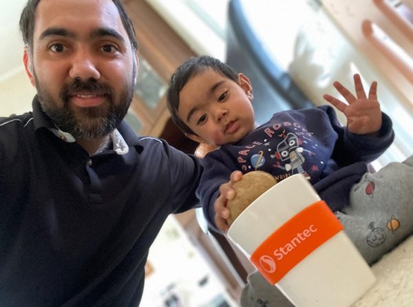 Maninder with his baby and a Stantec mug.