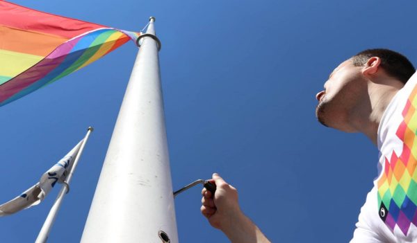 Stantec employee raising pride flag