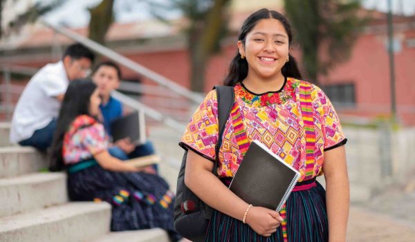 Portrait of an indigenous college student with books in hands in the university.