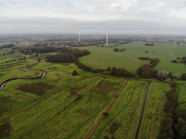 Aerial shot of the Suffolk countryside with wind turbines in the distance