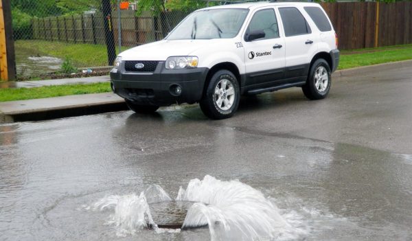 Water spraying out of a manhole on a roadway
