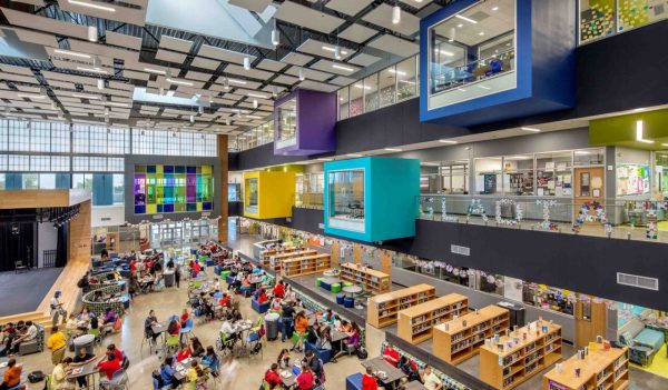 Open area with view of student seating, stage, library and upper levels with color block meeting areas