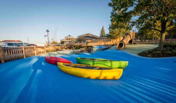 Outdoor play area with canoes on a faux body of water