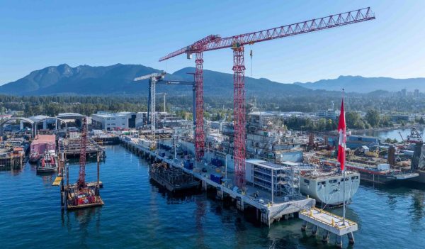 View of the shipyard with ships and crane and mountains in the background