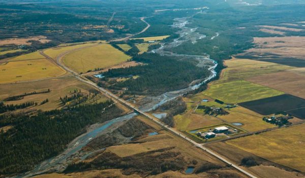 Aerial view from a plane of the facility alongside the river, surrounded by fields.
