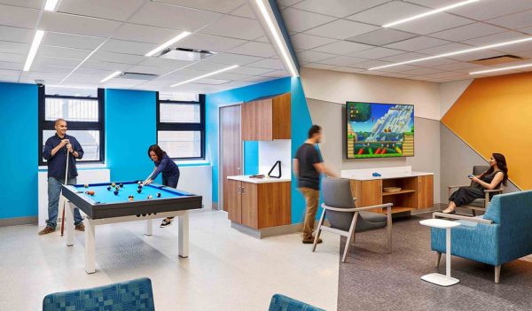 Employees in staff area with pool table and gaming console.
