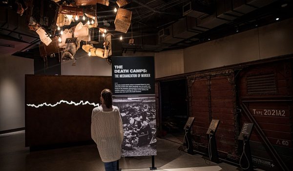 Person standing in front exhibit signage.