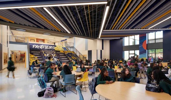 Corridor and large open space for gathering with stairs used for seating and students at tables