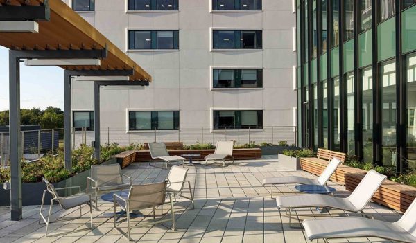 Rooftop patio with chairs and lounger seating.