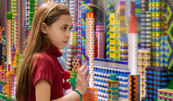 Close up of a girl building colorful towers with lego.