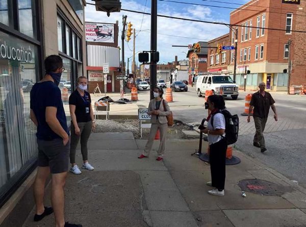 People standing on the sidewalk of a city street talking