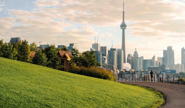 Early morning runner on a pedestrian path with the downtown Toronto skyline in the background.